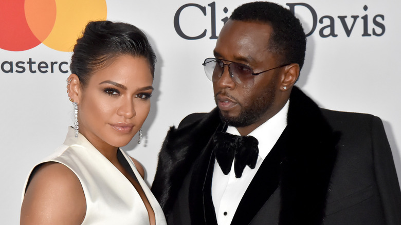 Cassie posing next to tuxedo-wearing Diddy at red carpet event
