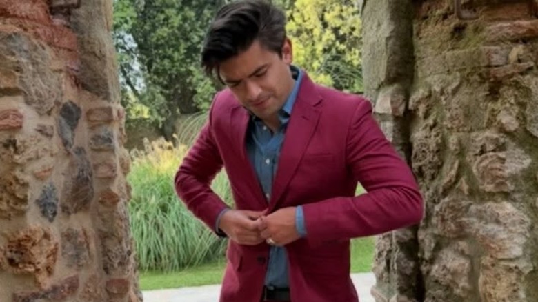 Michael Consuelos buttoning his jacket