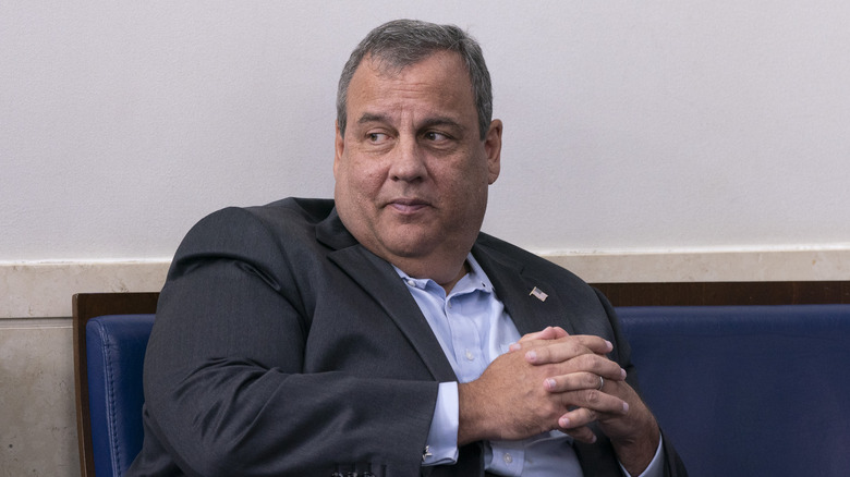 Chris Christie sitting on a chair with hands folded