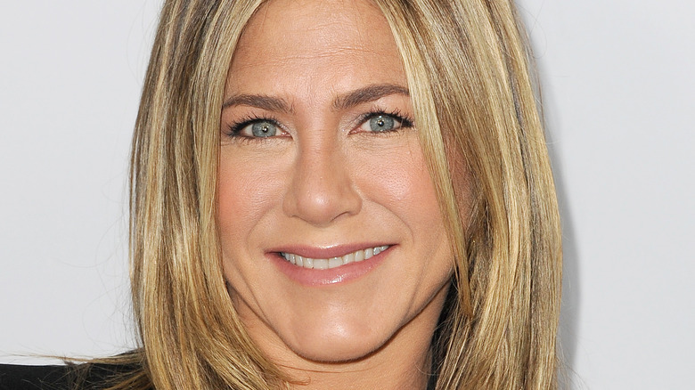 Jennifer Aniston smiles in a black outfit