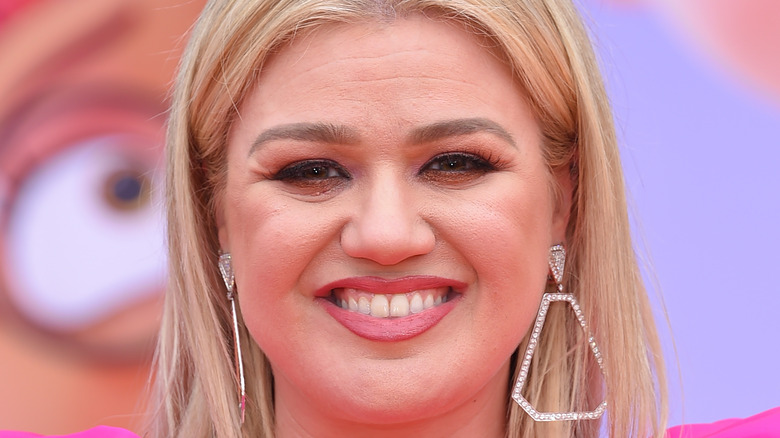 Kelly Clarkson with wide smile and large earrings