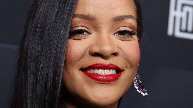 Rihanna smiling in red lipstick