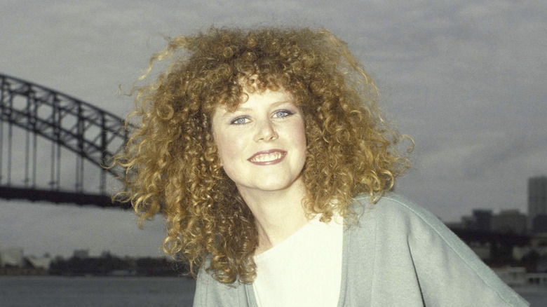 Young, redheaded Nicole Kidman poses in front of Sydney Harbour Bridge