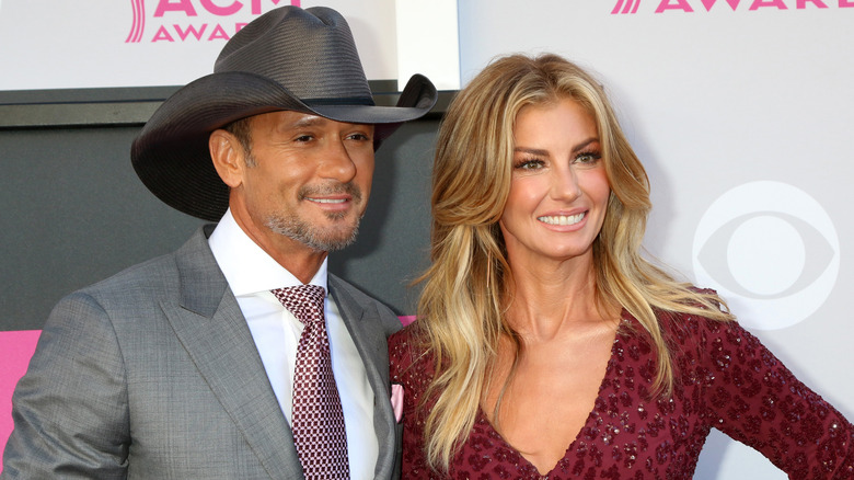 Tim McGraw and Faith Hill smile on a red carpet