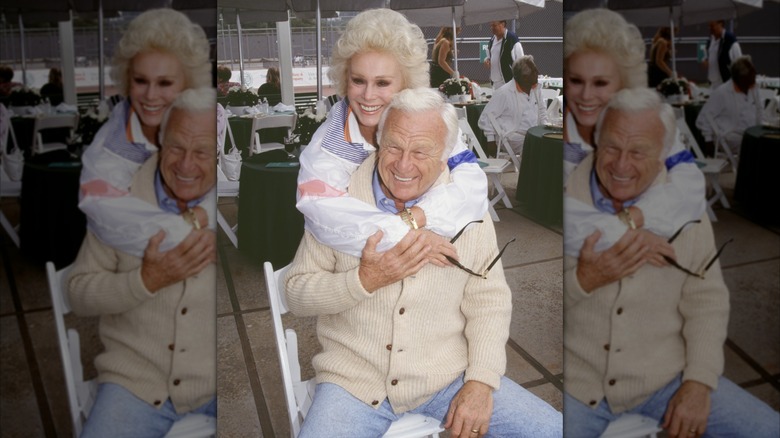 Eva Gabor pictured hugging a seated Eddie Albert in a restaurant