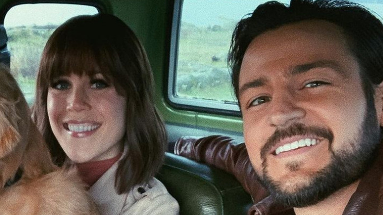 Erin Krakow and Tyler Hynes smile in a car