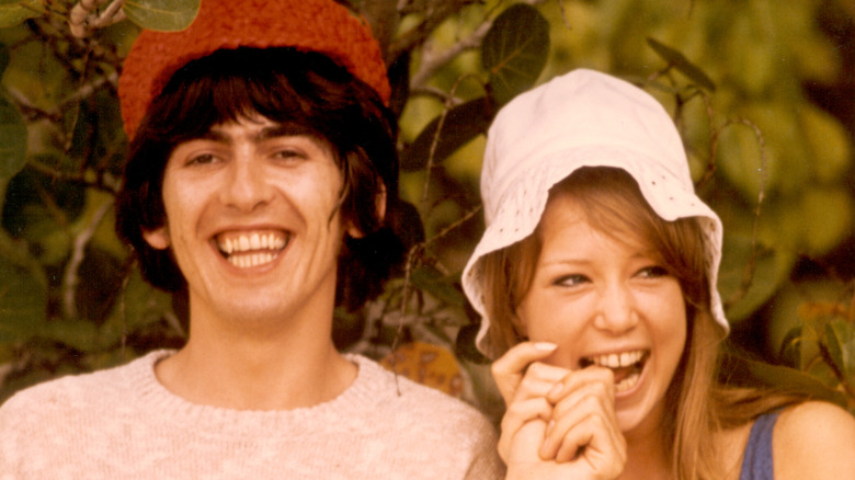 Pattie Boyd playfully bites George Harrison's finger in 1966