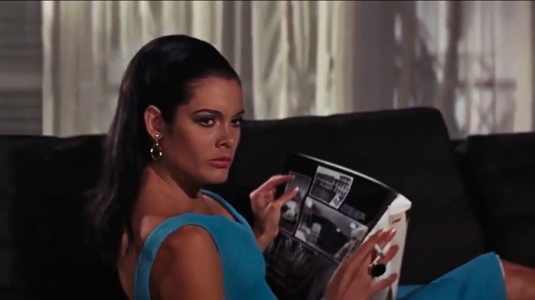 Martine Beswick seated, looking away