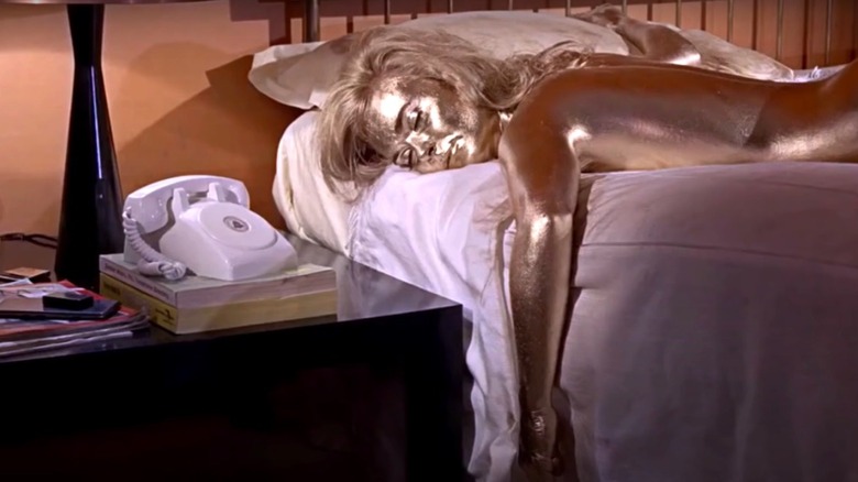 Shirley Eaton laying in bed, covered in gold