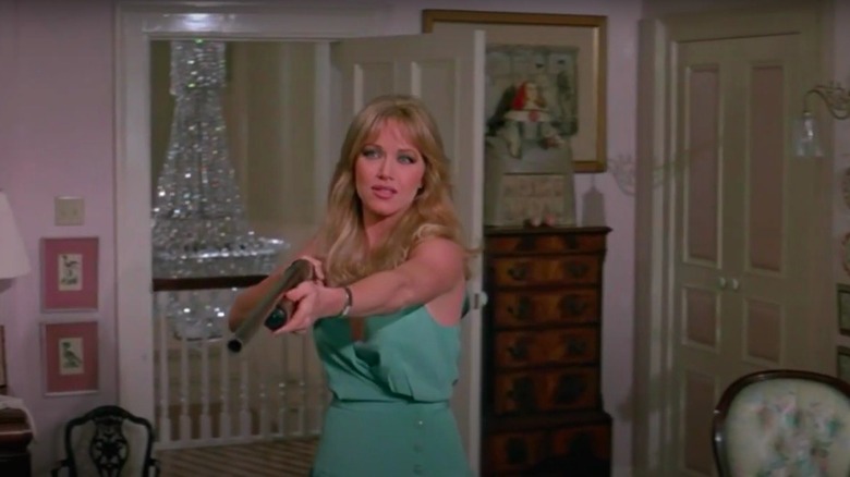 Tanya Roberts pointing a shotgun