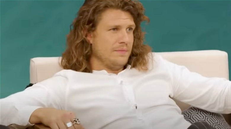 Jack Stirrup long hair sitting in white chair