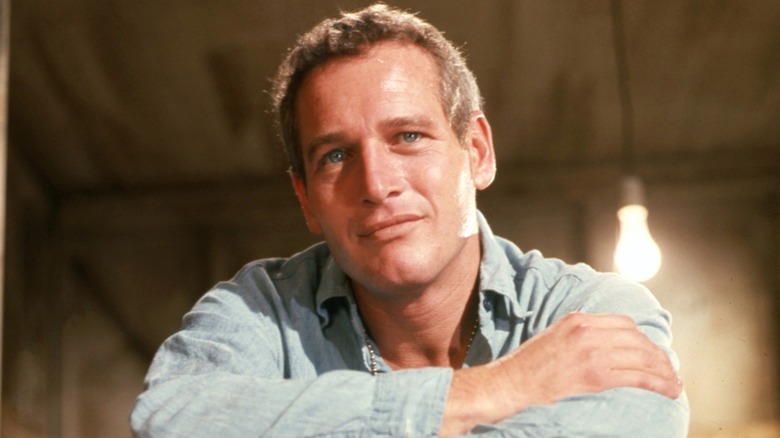 Paul Newman with his arms crossed.