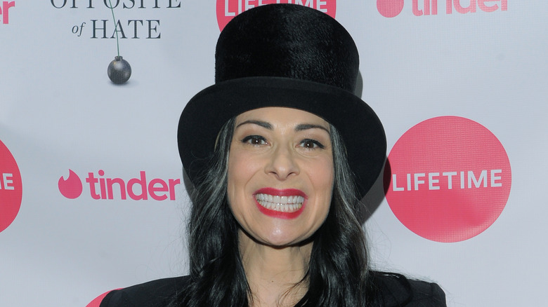 Stacy London grinning large black felt top hat