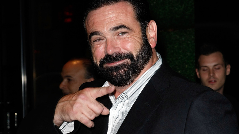 Billy Mays smiling and pointing in a suit