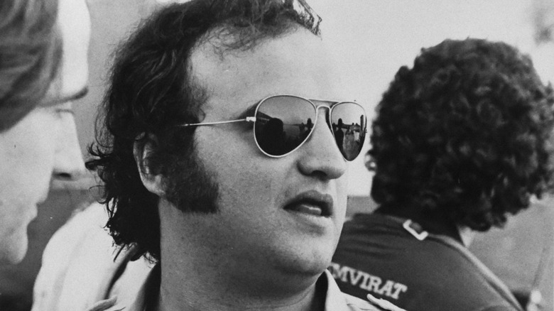 A black and white photo of John Belushi wearing sunglasses