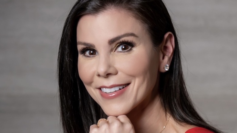 Heather Dubrow smiling, resting her chin on her fist 