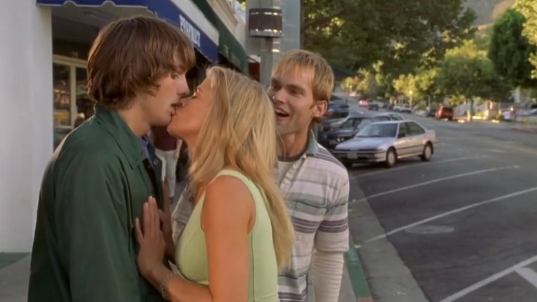 Ashton Kutcher and Kristy Swanson kissing in "Dude, Where's My Car?" as Seann William Scott looks on.