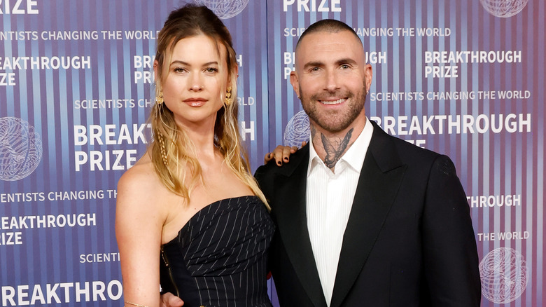 Adam Levine and Behati Prinsloo posing together on a red carpet
