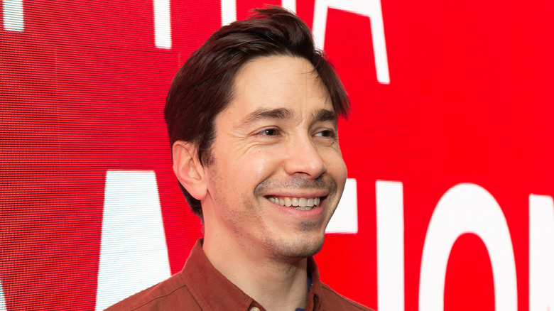 Justin Long smiling and looking to the side