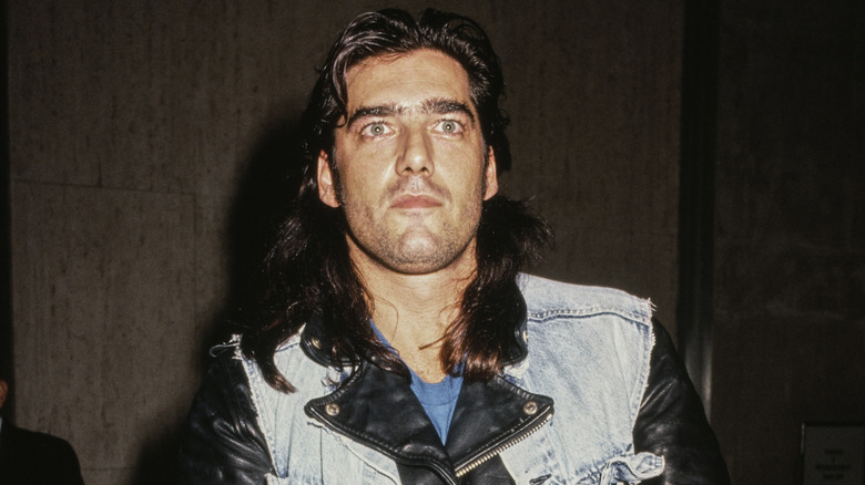 Ken Wahl wearing a leather jacket and denim vest at an event in 1990.