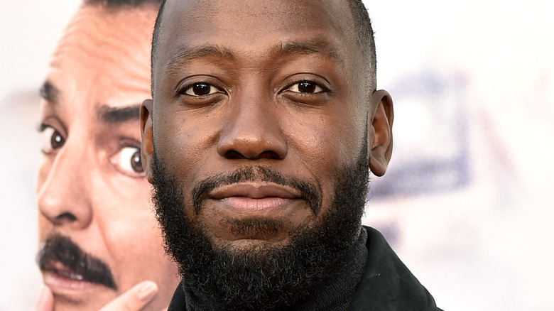 Lamorne Morris wears a black jacket and turtleneck at a premiere