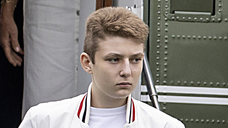 Barron Trump scowling white jacket