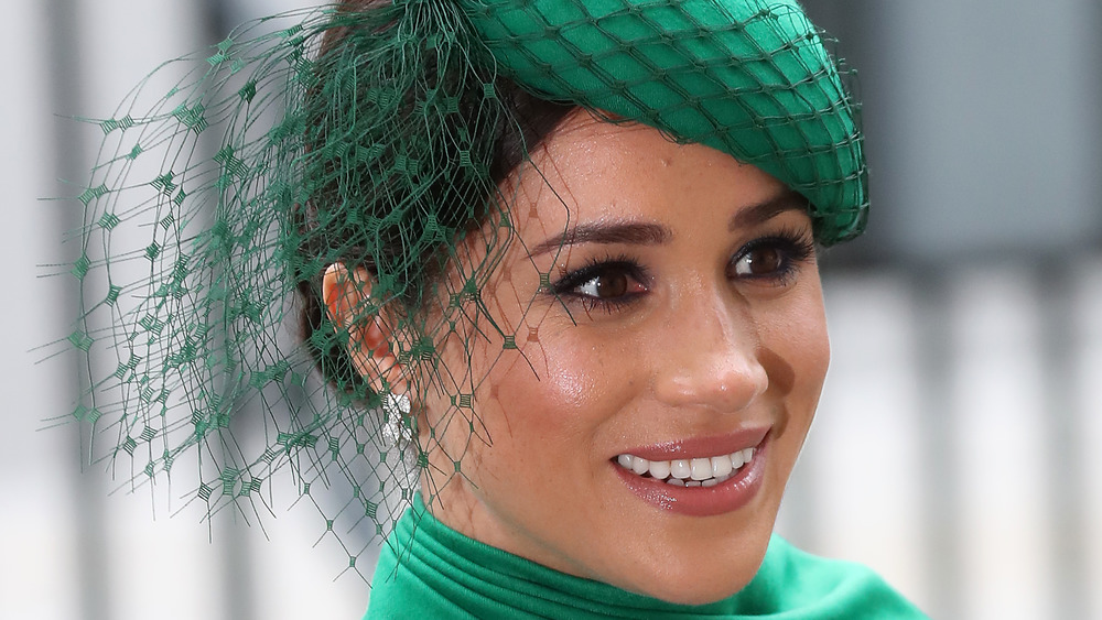 Meghan Markle smiling in green hat