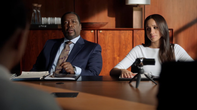 Wendell Pierce and Meghan Markle seated at a table