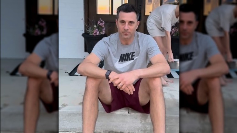 Steve Lepore wearing a gray Nike shirt and sitting outside on a step