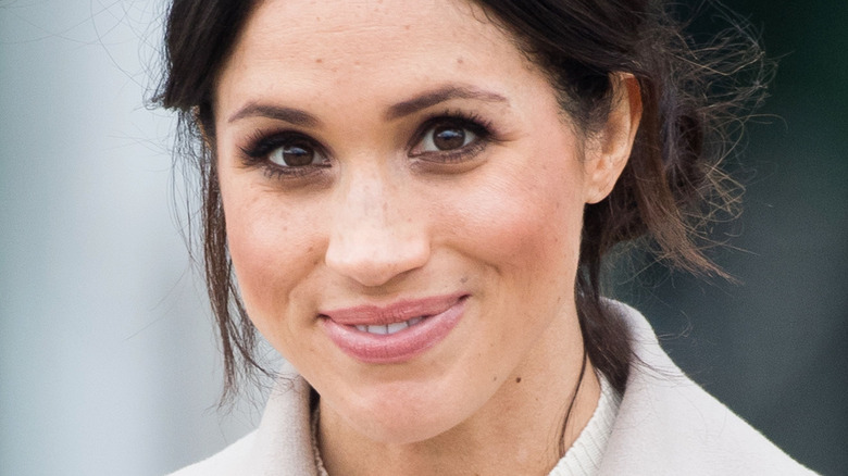 Meghan Markle smiling at the camera