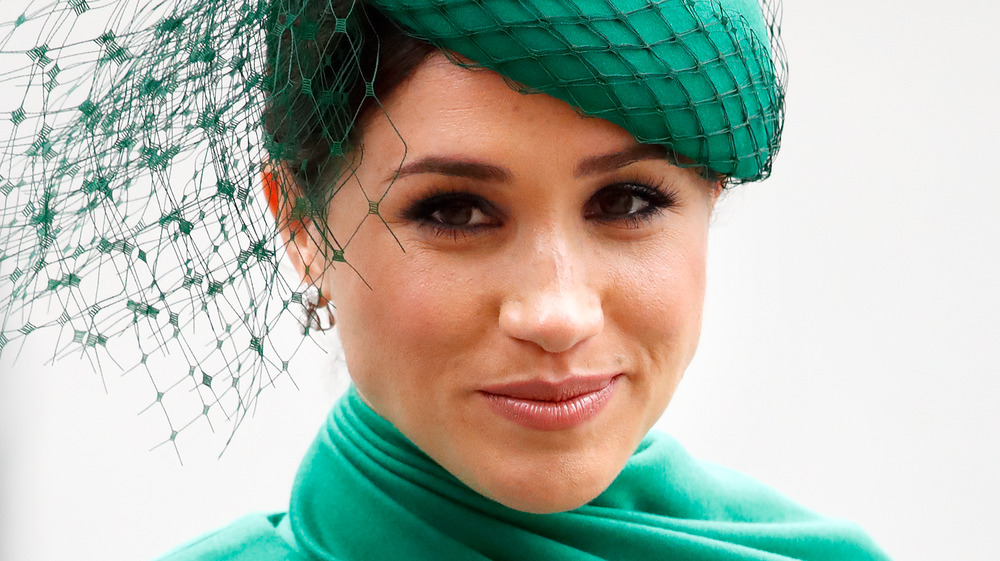 Meghan Markle, the Duchess of Sussex, smiling and wearing emerald green