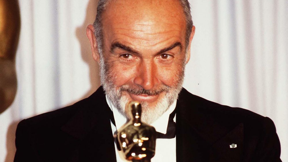 Sean Connery smiling while holding his Oscar
