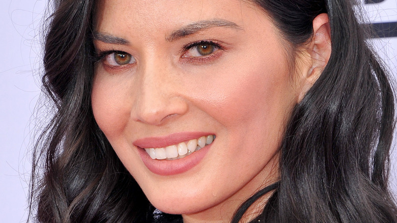 Olivia Munn smiling at a movie premiere