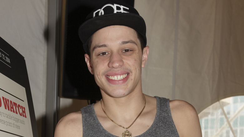 Pete Davidson wearing a tank top and black hat