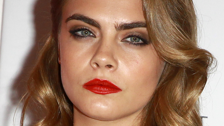 Cara Delevingne solemn wavy hair bright red lip