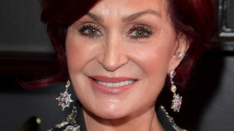 Sharon Osbourne red hair smiling with earrings