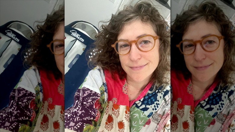 Mayim taking a selfie alongside hyperbaric chamber