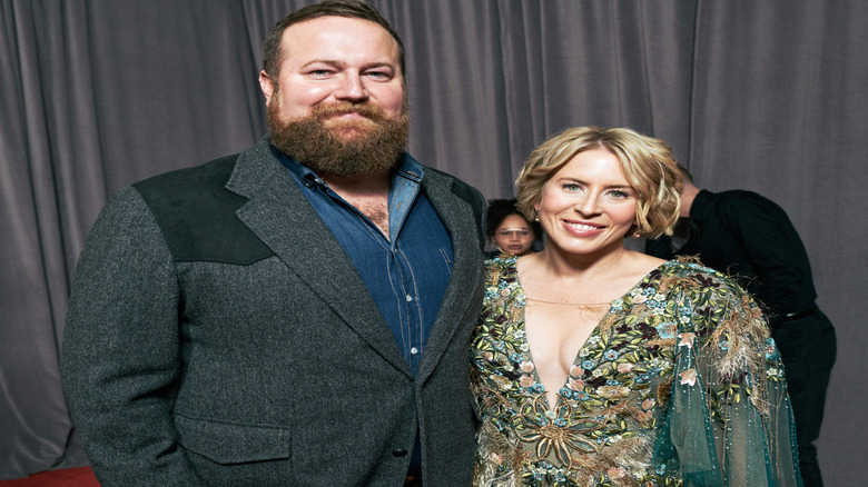 Ben and Erin Napier in front of dark courtains.