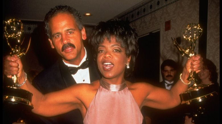 Oprah Winfrey shows off two Emmys as Stedman Graham hugs her in the '90s