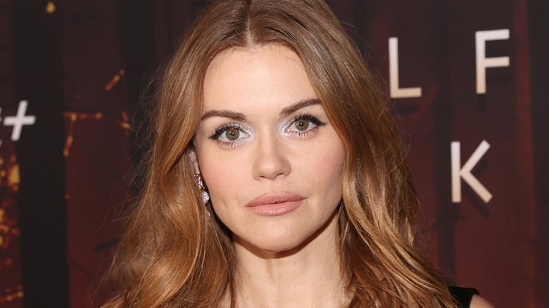 Holland Roden red hair red background, looking at camera