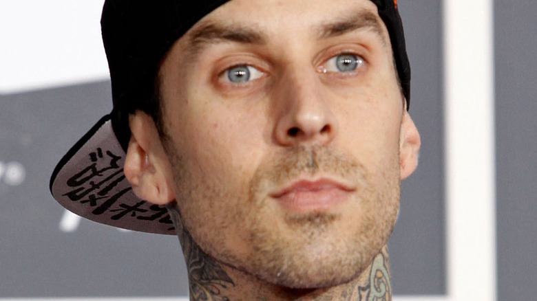 Travis Barker wearing hat with serious expression