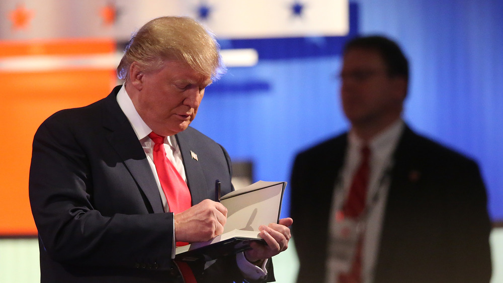 Donald Trump signing a book