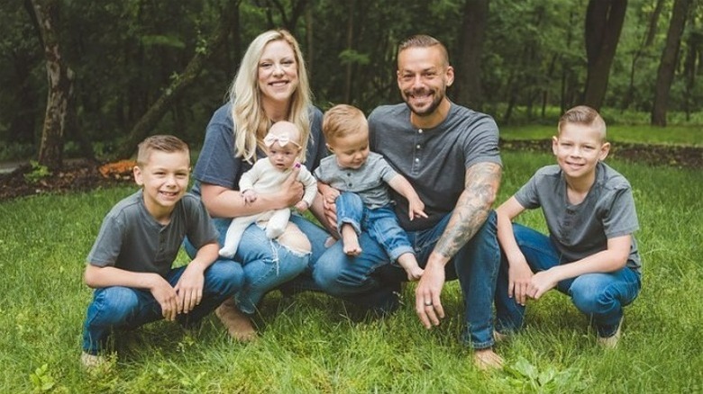 Briana and Ryan Culberson posing in a forest with their four children