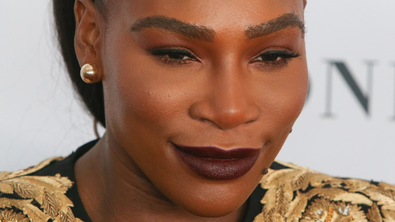 Serena Williams poses in dark purple lipstick
