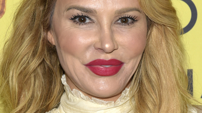 Brandi Glanville wearing red matte lipstick on a red carpet