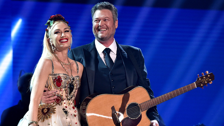Gwen Stefani and Blake Shelton smiling on stage