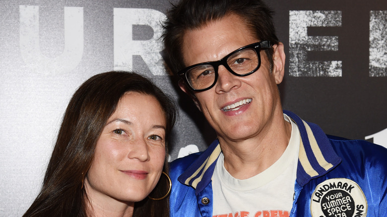 Naomi Nelson smiling Johnny Knoxville black rim glasses leaning in