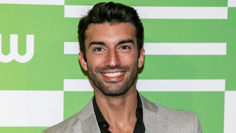 Justin Baldoni smiling while wearing a suit