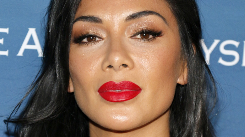 Nicole Scherzinger looking at camera with serious expression and red lipstick