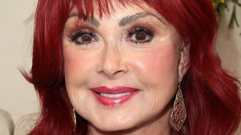 Naomi Judd smiles on a red carpet 